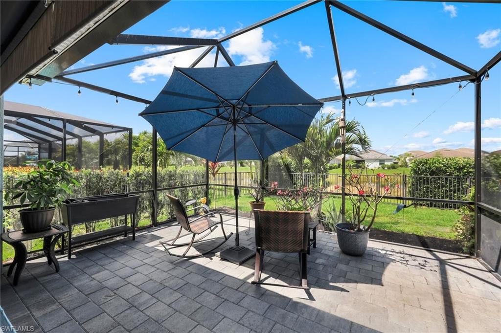 2193 Clementine Street Naples, FL 34120 - Photo 28 of 36 a view of a patio with a table and chairs under an umbrella