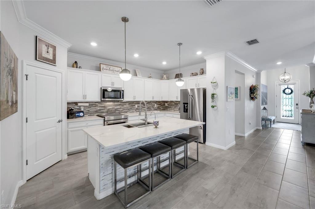 2193 Clementine Street Naples, FL 34120 - Photo 9 of 36 a large kitchen with a table and chairs