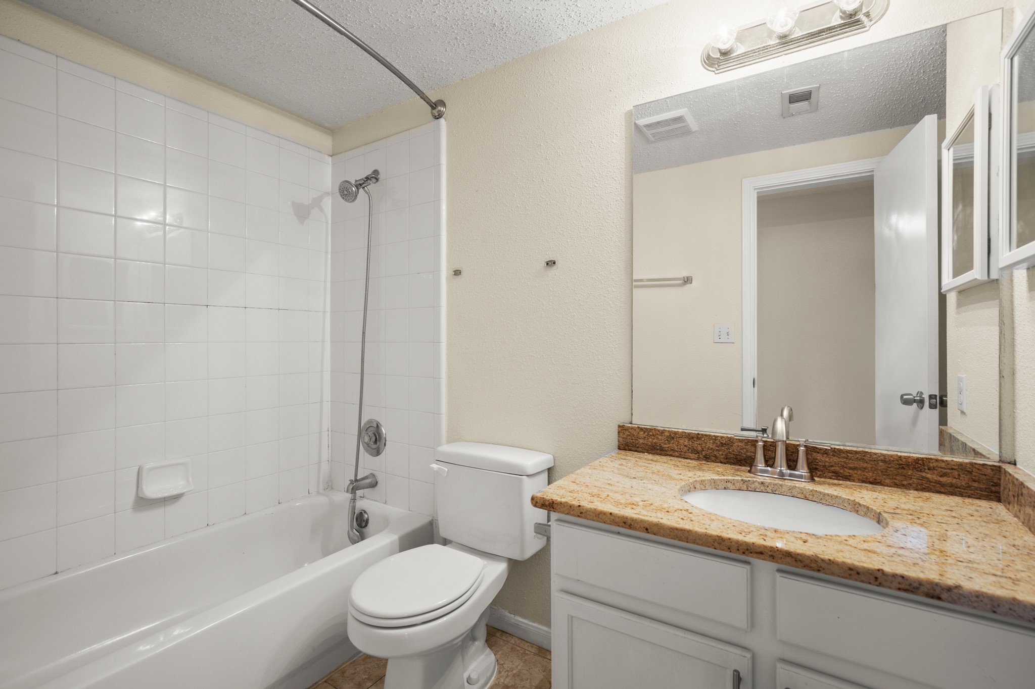 712 West 21st Street, Unit 101 Austin, TX 78705 - Photo 11 of 17 a bathroom with a granite countertop sink a toilet and a bathtub