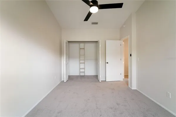 an empty room with chandelier fan