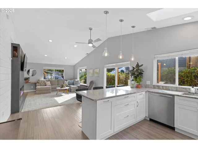 a large white kitchen with cabinets a sink and appliances
