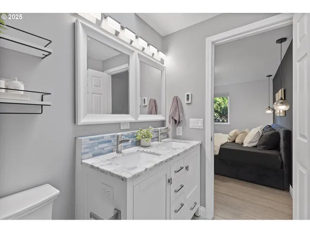 a en suite bathroom with a granite countertop sink and a mirror