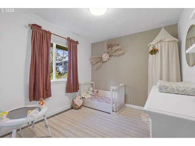 a bedroom with a bed and a wooden floor