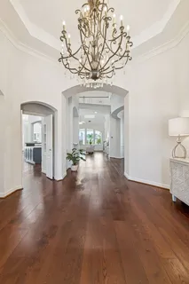 a view of a livingroom with wooden floor and a chandelier