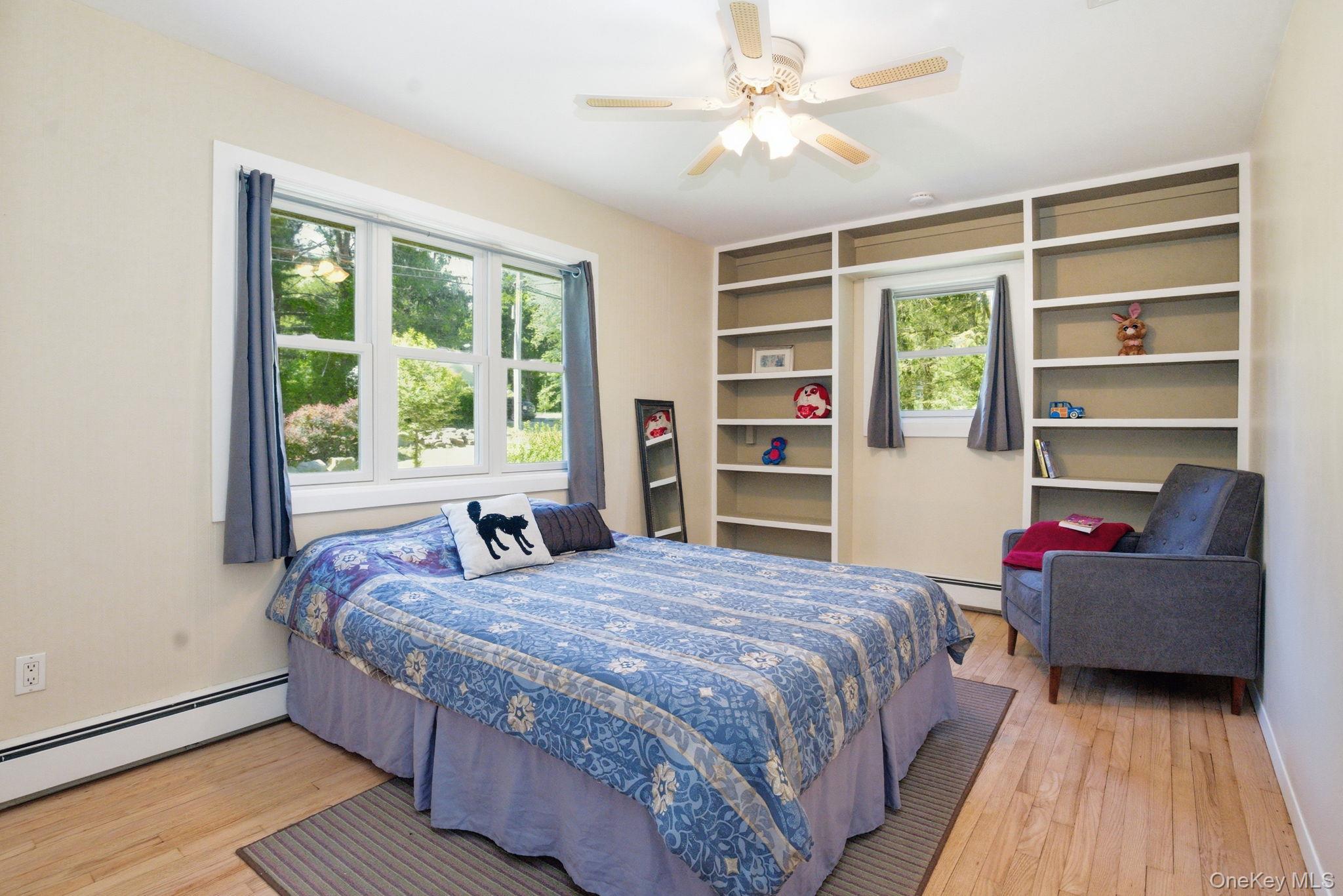 35 Deans Bridge Road Somers, NY 10589 - Photo 15 of 49 A bright, generously sized bedroom with hardwood floors and handsome built-in shelving framing the windows.