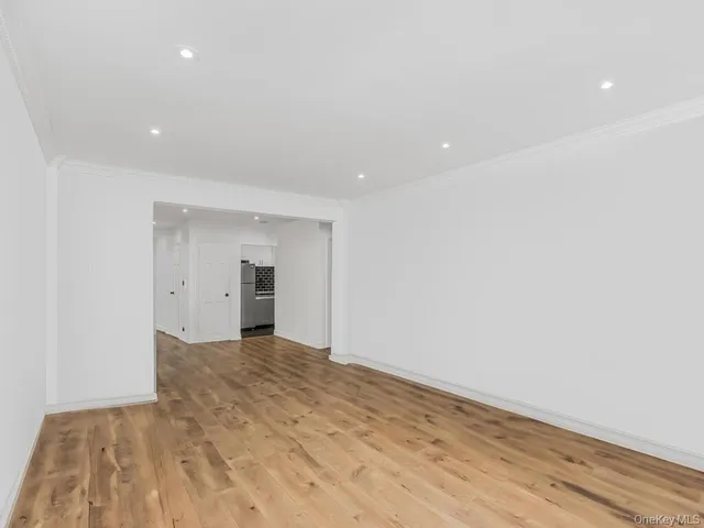 a view of a big room with wooden floor and kitchen