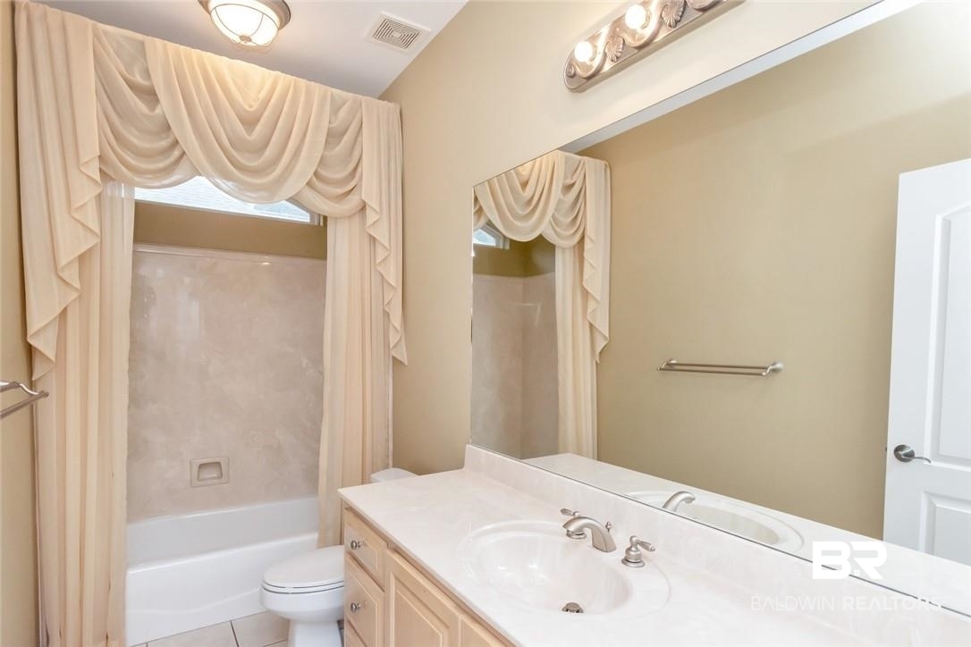 8837 Dawes Lake Road South Mobile, AL 36619 - Photo 25 of 44 Full bathroom featuring shower / tub combination, tile patterned flooring, toilet, and vanity