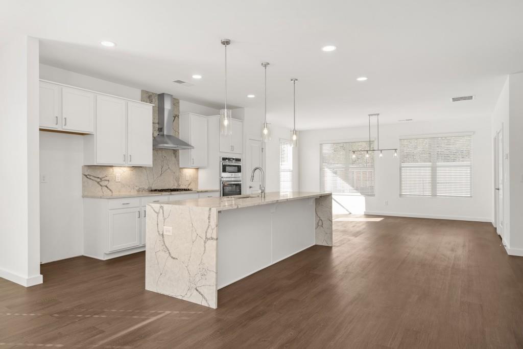 1078 Glen Opal Drive Decatur, GA 30032 - Photo 17 of 40 a large white kitchen with kitchen island a sink a center island stainless steel appliances and a fireplace