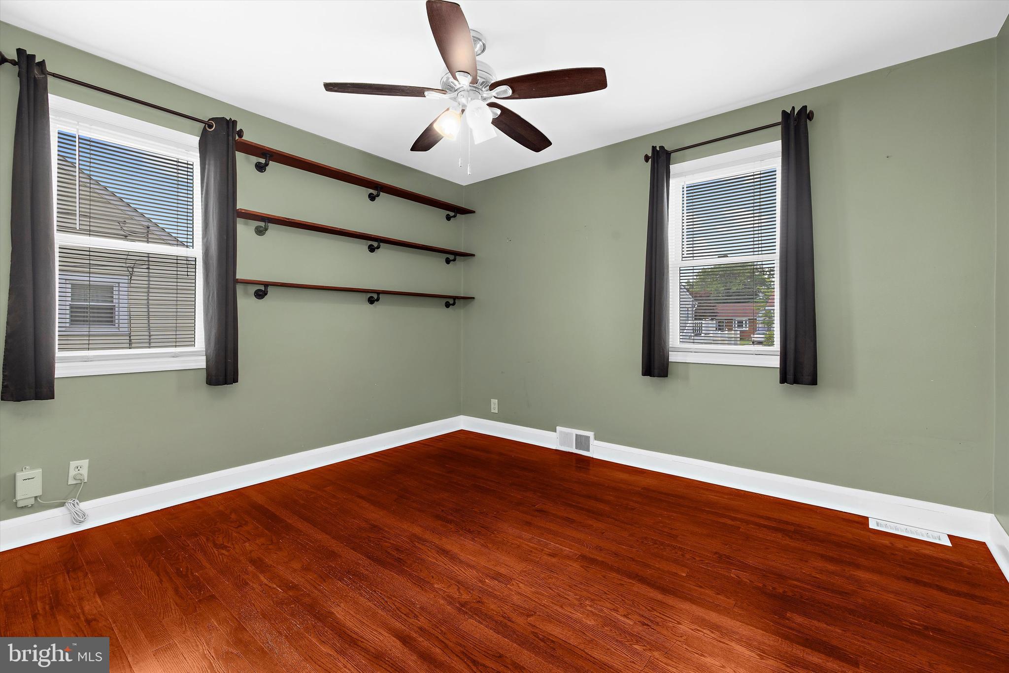 8464 Geneva Road Pasadena, MD 21122 - Photo 14 of 59 an empty room with wooden floor fan and windows
