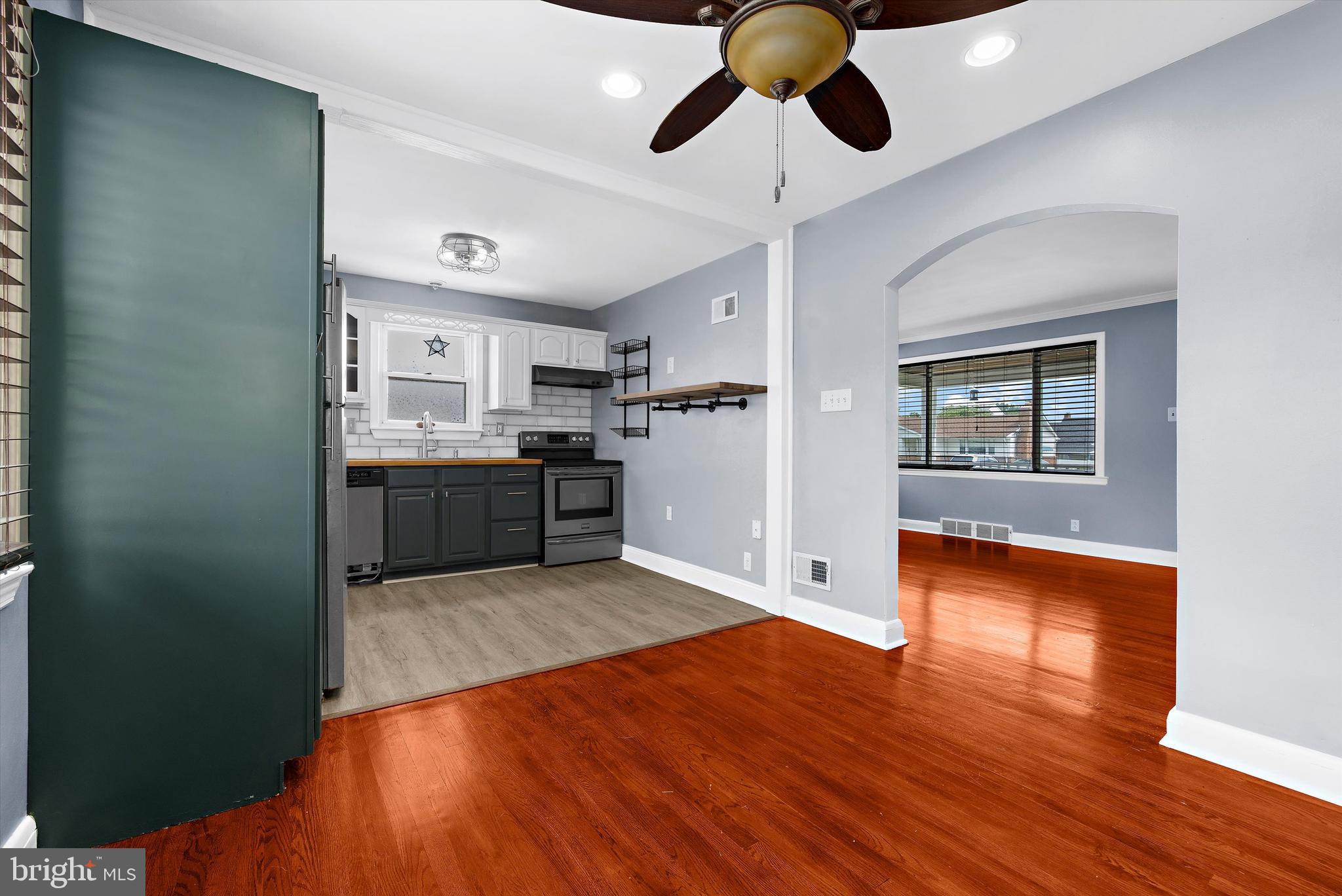 8464 Geneva Road Pasadena, MD 21122 - Photo 10 of 59 a large kitchen with a wooden floor and stainless steel appliances