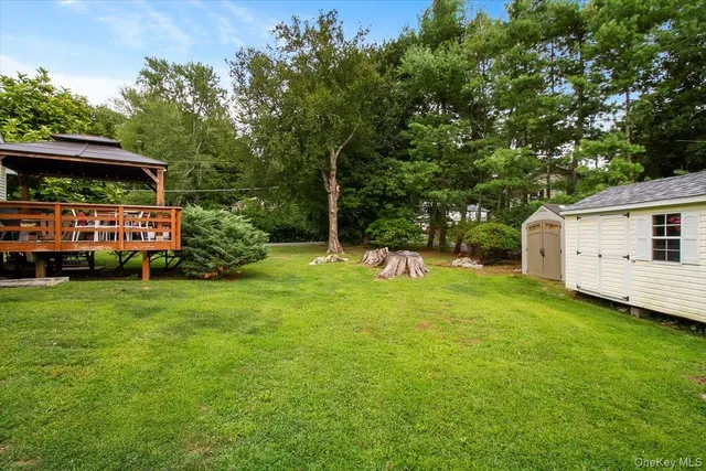 a view of a house with backyard and sitting area