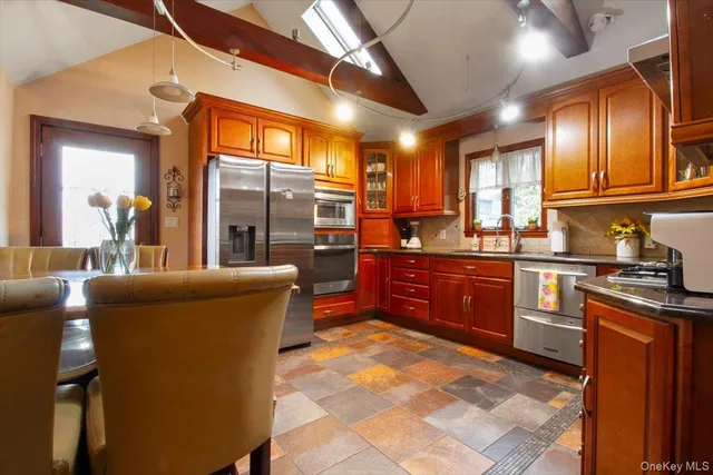 a kitchen with stainless steel appliances granite countertop a sink stove and refrigerator