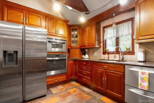 a kitchen with stainless steel appliances granite countertop a refrigerator and a sink