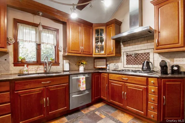 a kitchen with stainless steel appliances granite countertop wooden cabinets a sink and a window