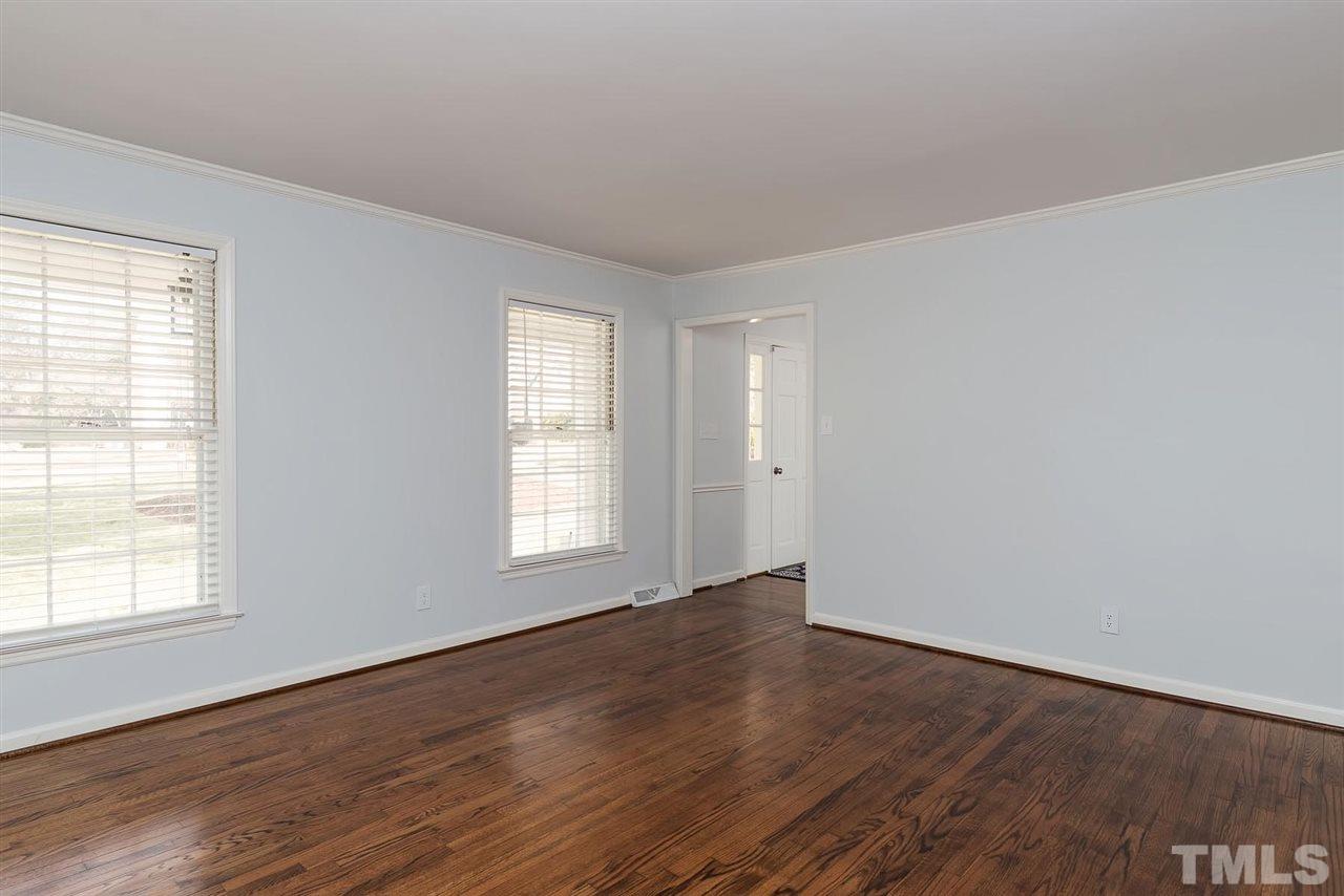 5828 Morning Forest Drive Raleigh, NC 27609 - Photo 11 of 25 an empty room with wooden floor and windows