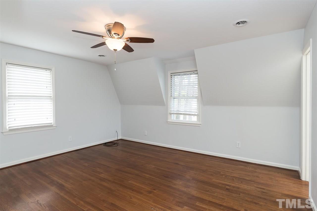 5828 Morning Forest Drive Raleigh, NC 27609 - Photo 14 of 25 a view of an empty room with wooden floor and a window