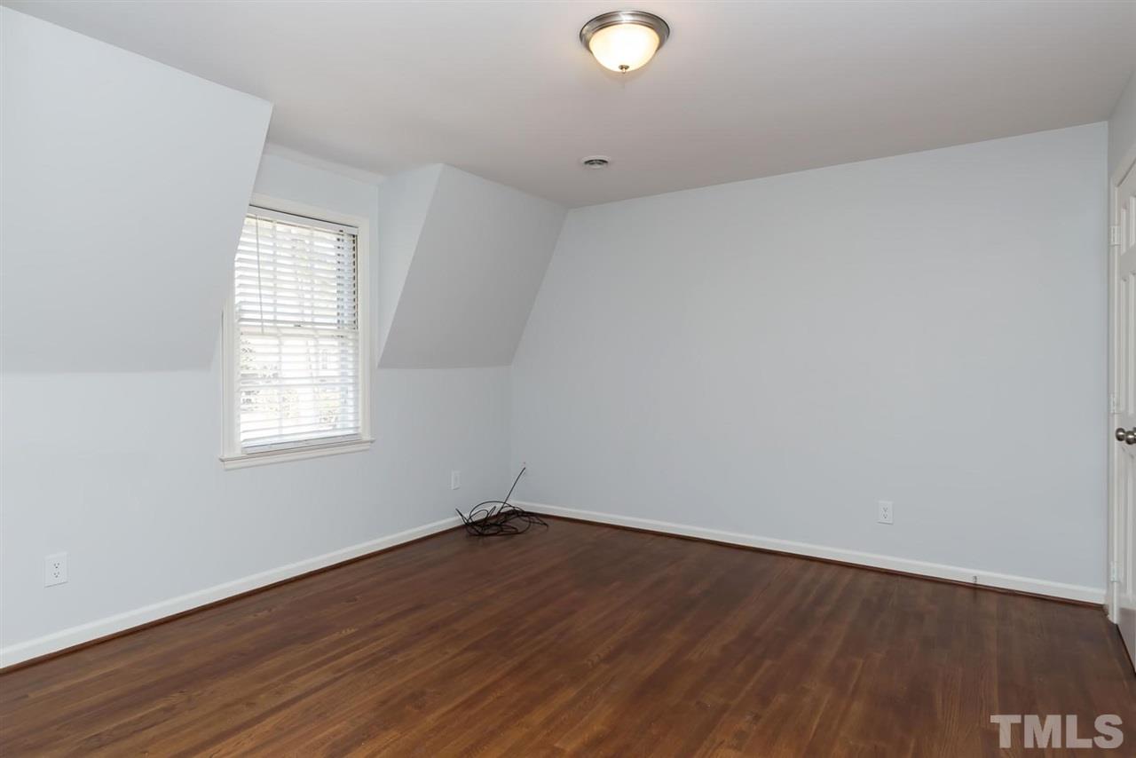 5828 Morning Forest Drive Raleigh, NC 27609 - Photo 19 of 25 an empty room with wooden floor and windows
