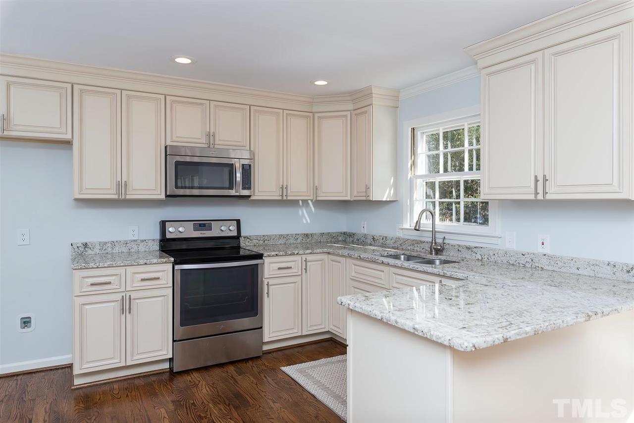 5828 Morning Forest Drive Raleigh, NC 27609 - Photo 3 of 25 a kitchen with granite countertop a sink cabinets and stainless steel appliances