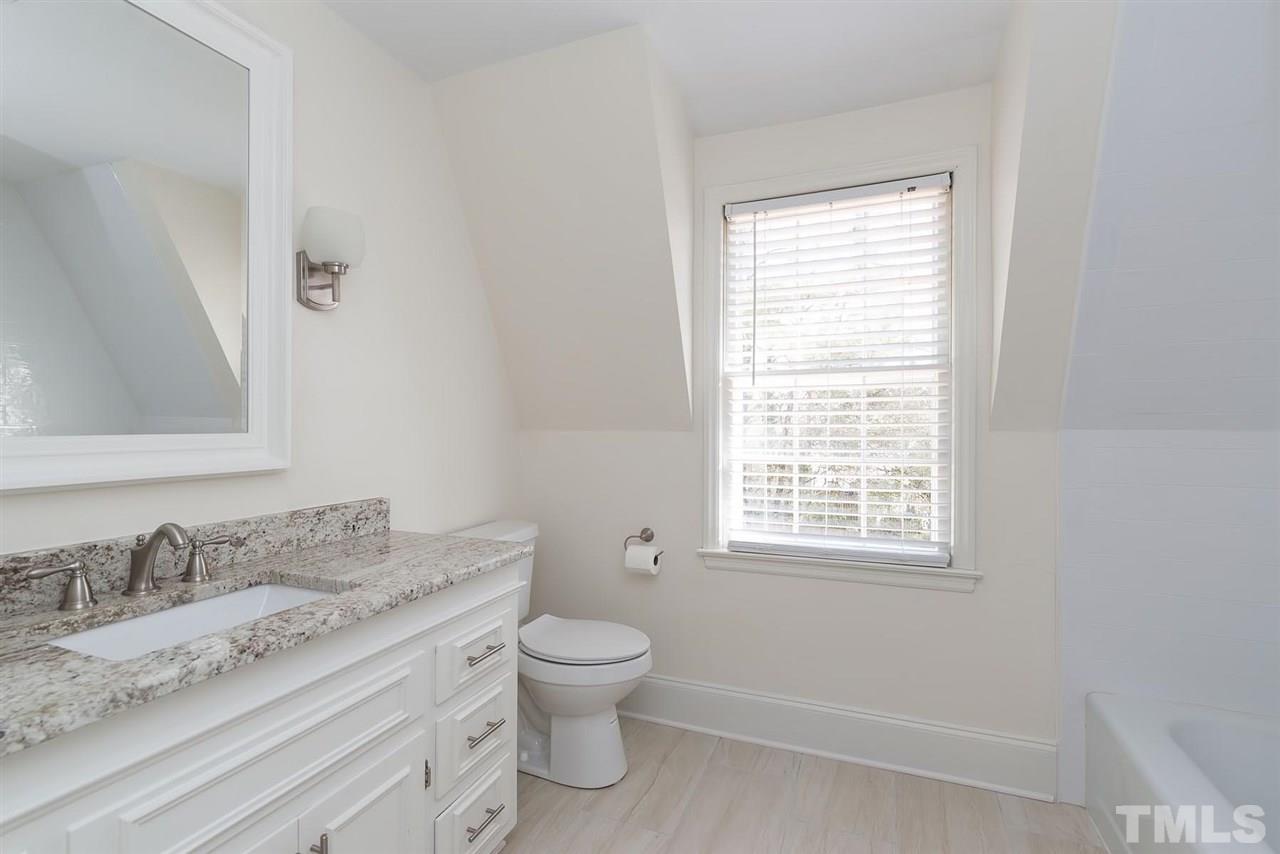5828 Morning Forest Drive Raleigh, NC 27609 - Photo 22 of 25 a bathroom with a granite countertop toilet a sink and a window