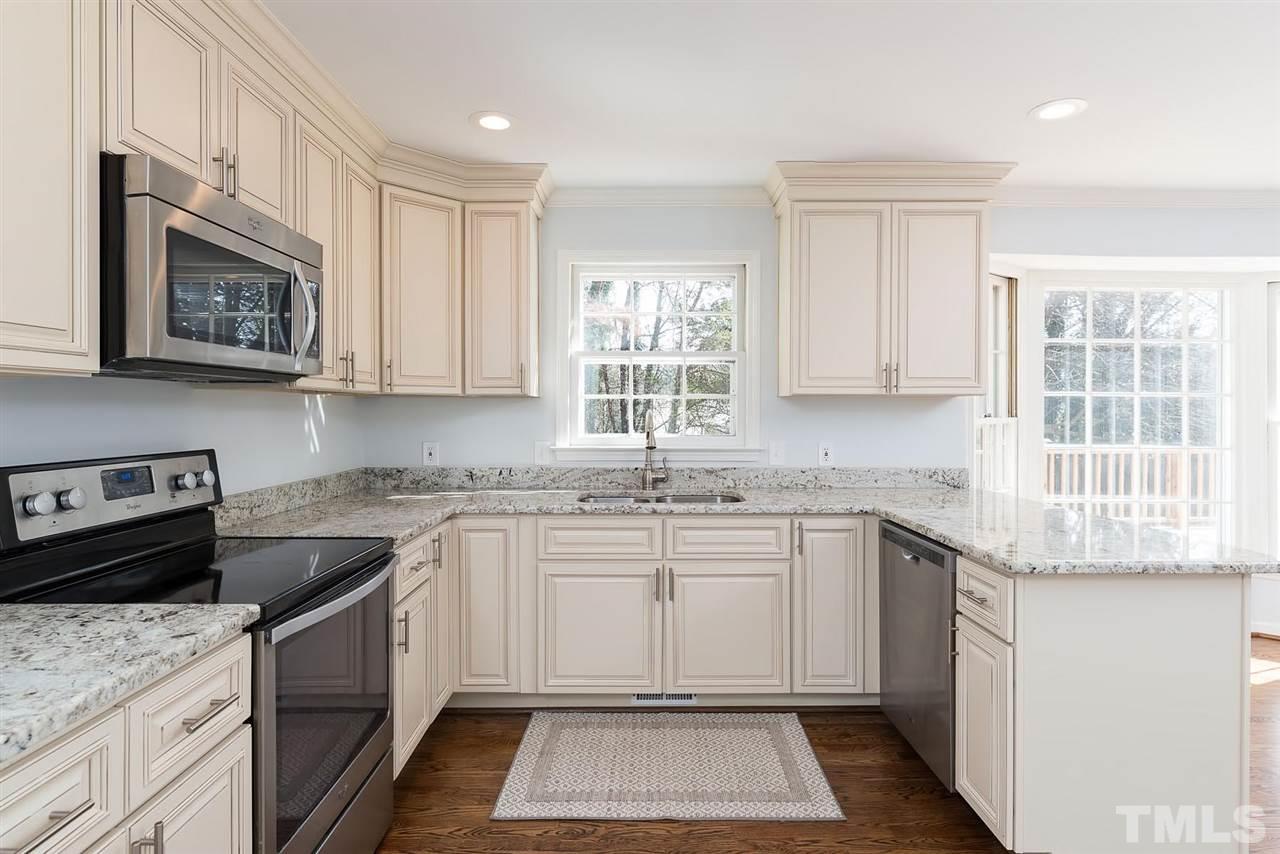 5828 Morning Forest Drive Raleigh, NC 27609 - Photo 4 of 25 a kitchen with a stove sink and cabinets