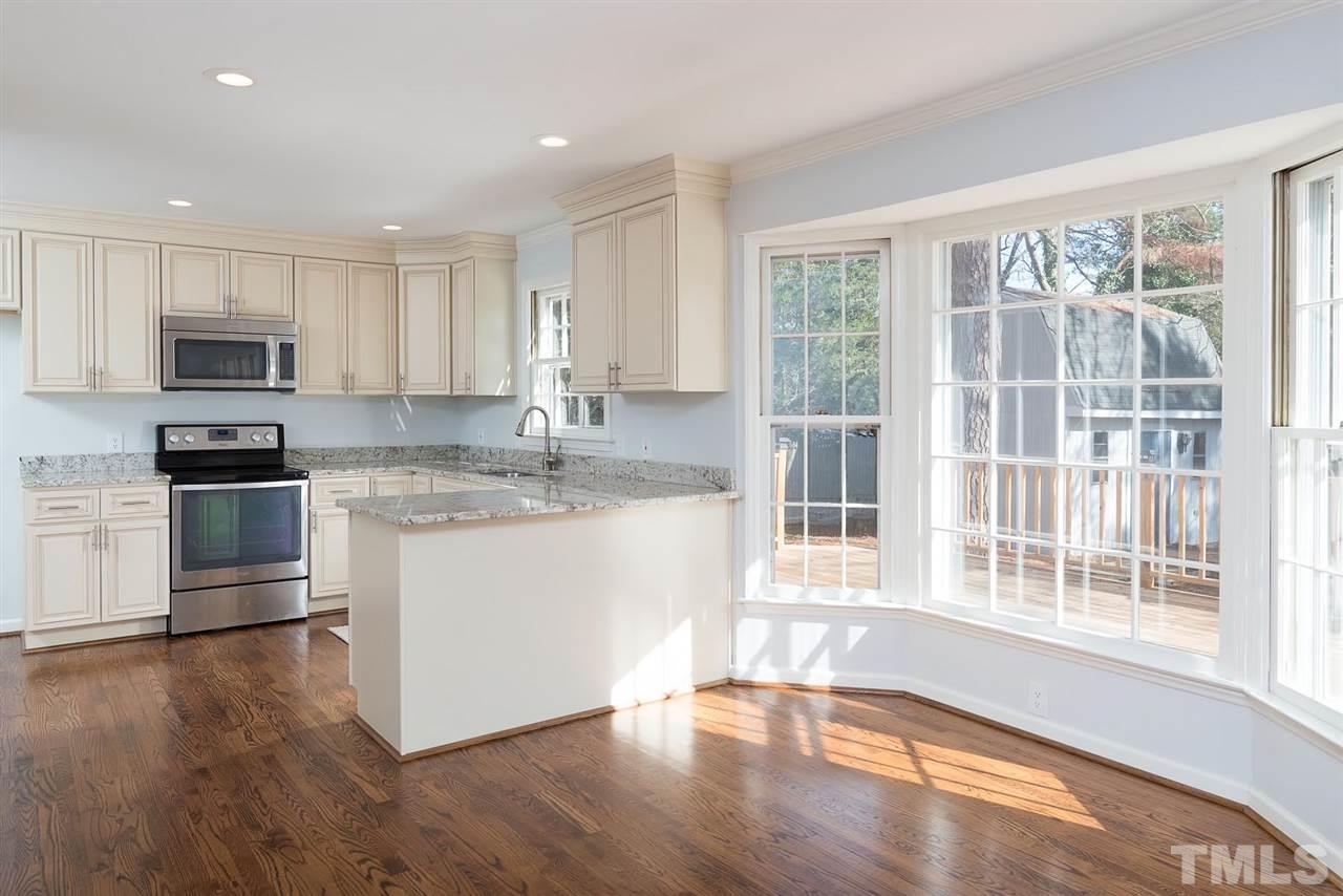 5828 Morning Forest Drive Raleigh, NC 27609 - Photo 5 of 25 a kitchen with stainless steel appliances granite countertop a stove a sink and a refrigerator