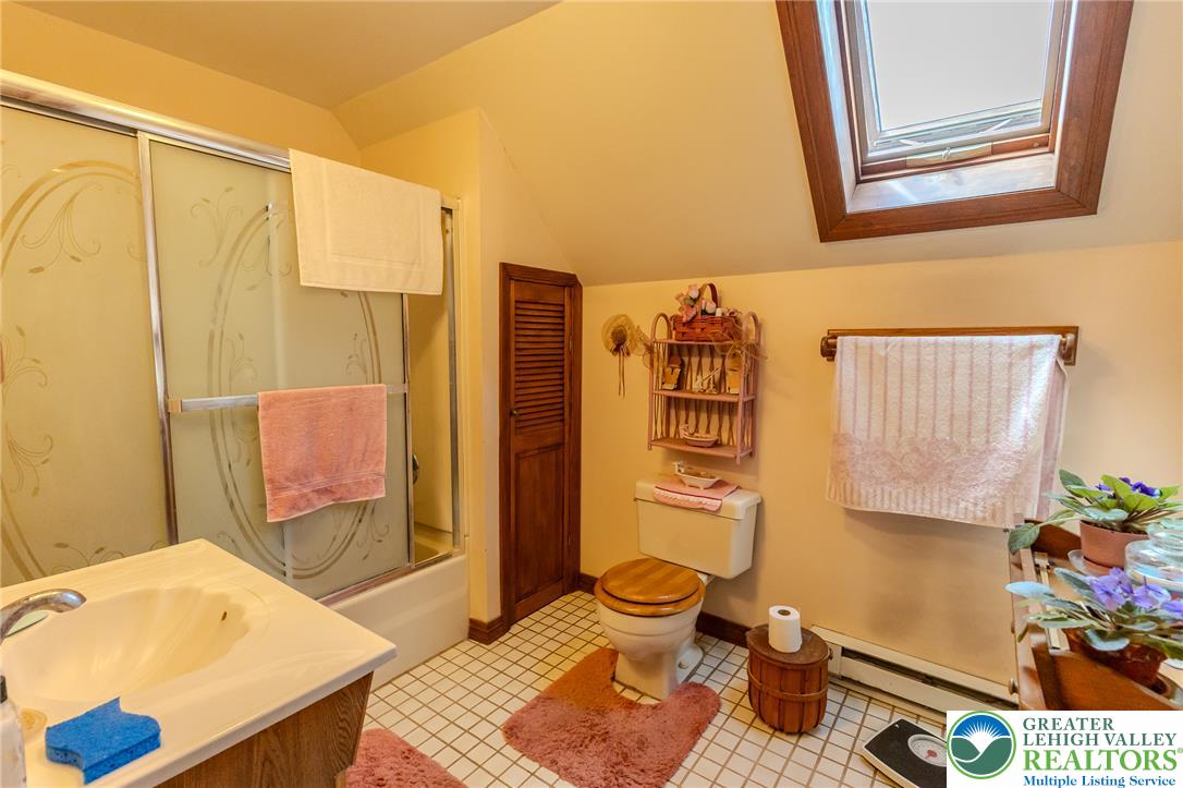40 Locke Heights Road Bangor, PA 18013 - Photo 27 of 28 A skylight brightens this charming bathroom, featuring a glass shower enclosure and classic tile flooring.