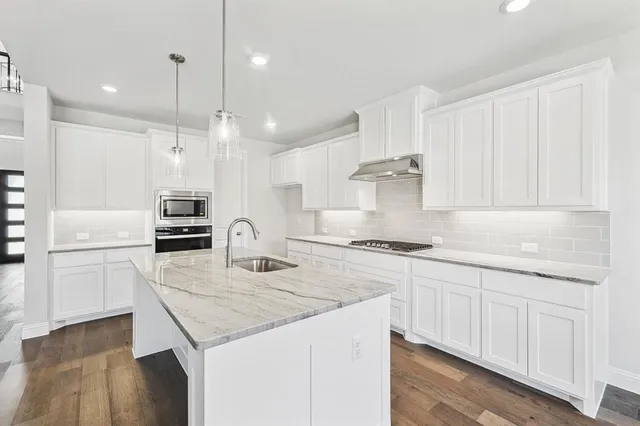 a kitchen with stainless steel appliances granite countertop a sink stove and refrigerator