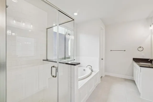 a bathroom with a granite countertop sink a mirror and shower