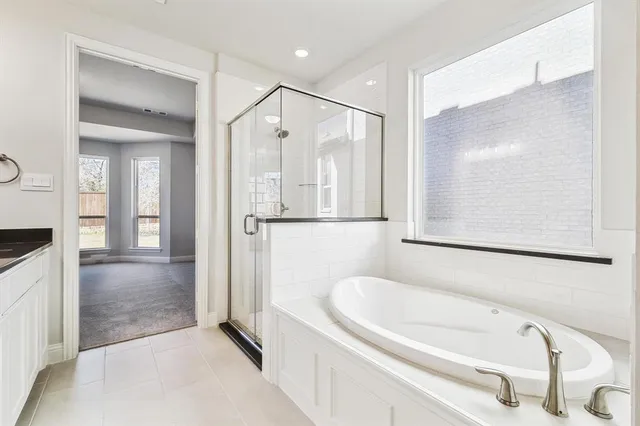 a bathroom with a tub a sink and a mirror