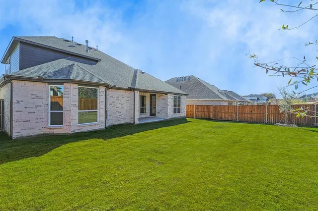 a view of a yard in front of a house with a large tree