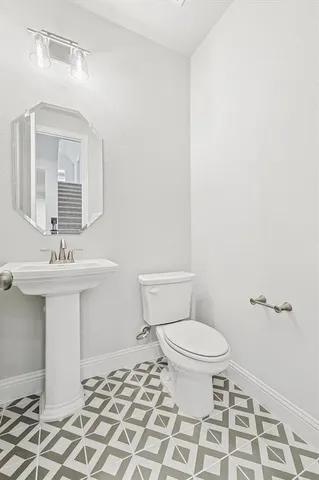 a bathroom with a sink toilet and a mirror