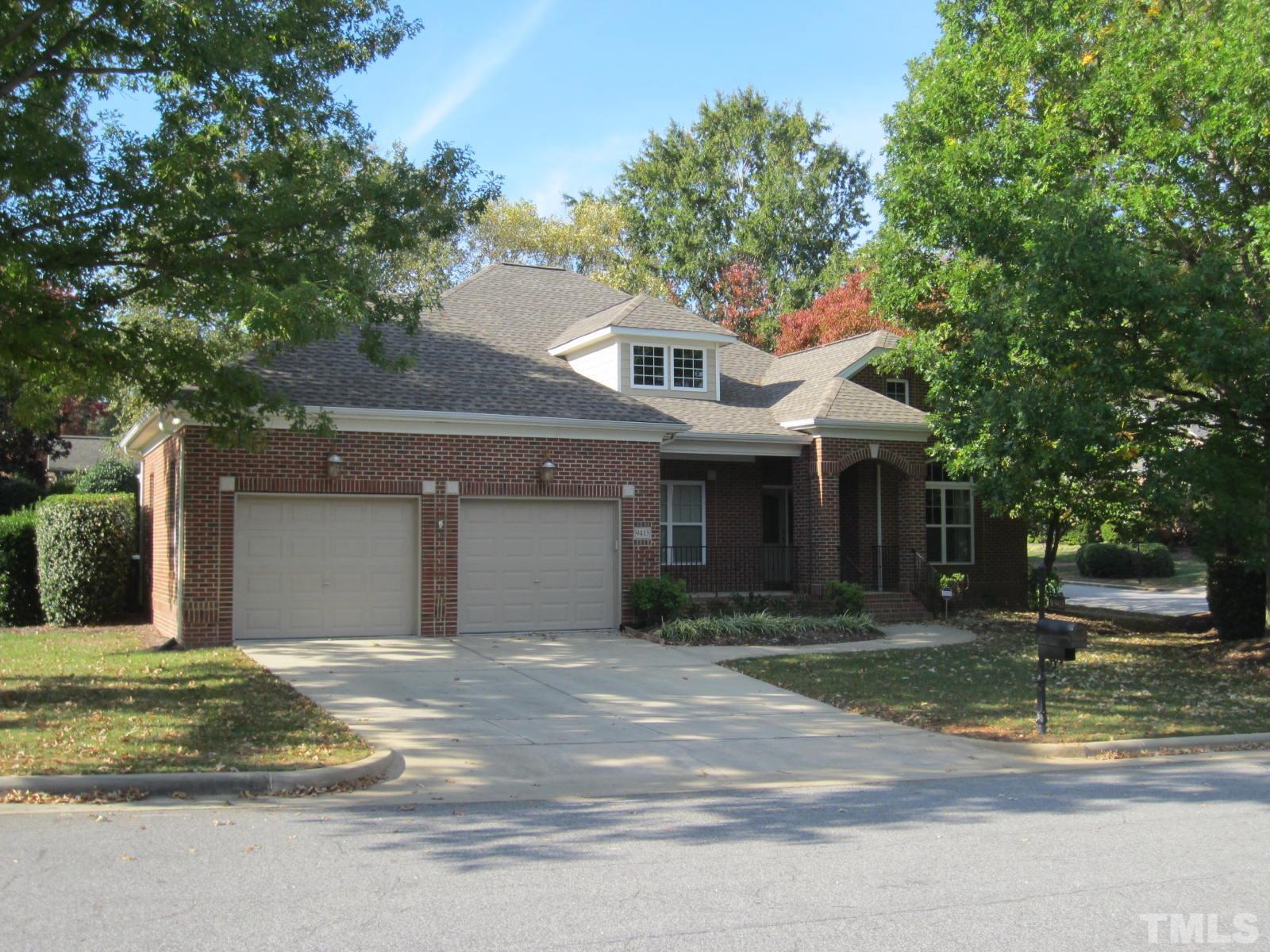 a front view of a house with a yard garage and trees