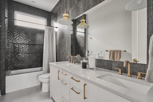 a bathroom with a double vanity sink toilet and shower