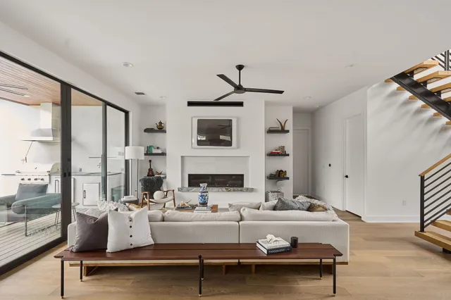 a living room with fireplace furniture and a large window