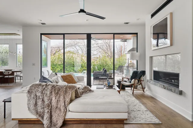 a living room with furniture large windows and a fireplace