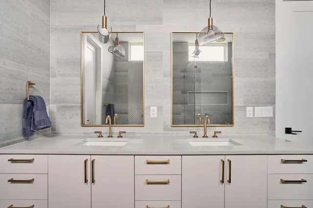 a bathroom with double vanity sinks and a mirror