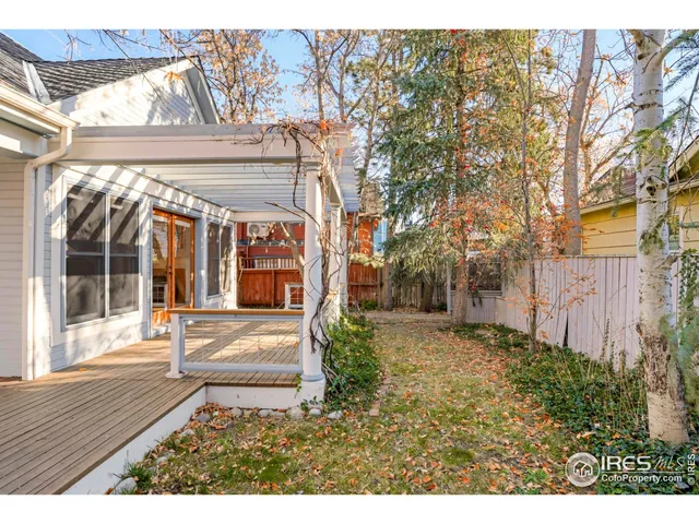 a view of a house with a large windows and flower plants