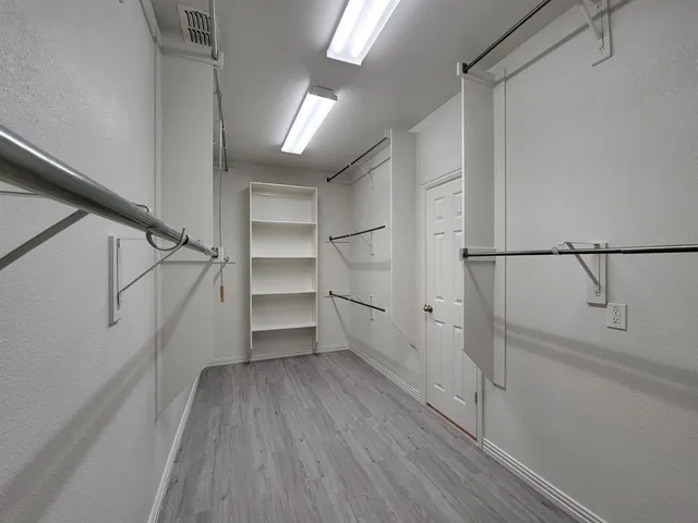 a spacious bathroom with a granite countertop sink a toilet a mirror and shower