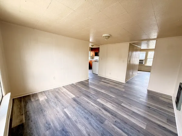 a view of empty room with wooden floor