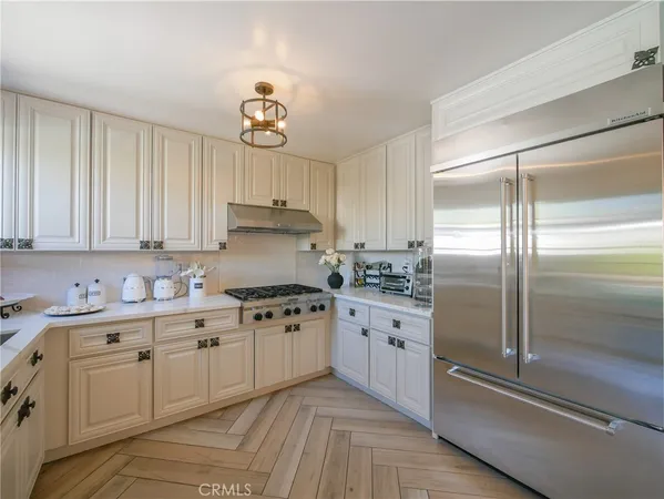 a kitchen with granite countertop a sink cabinets stainless steel appliances and a window