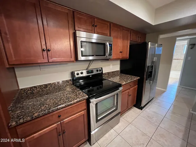 a kitchen with stainless steel appliances granite countertop a stove a sink and a microwave