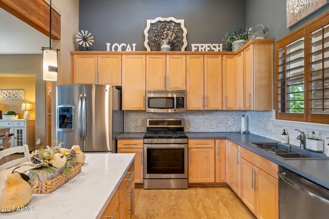 a kitchen with a refrigerator a stove a sink and dishwasher with wooden floor