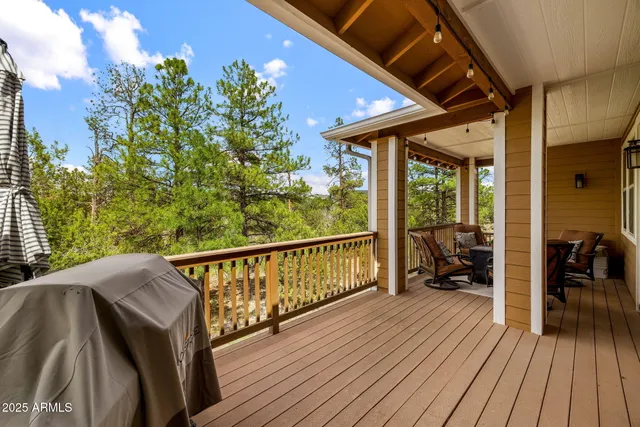 a balcony with wooden floor table and chairs