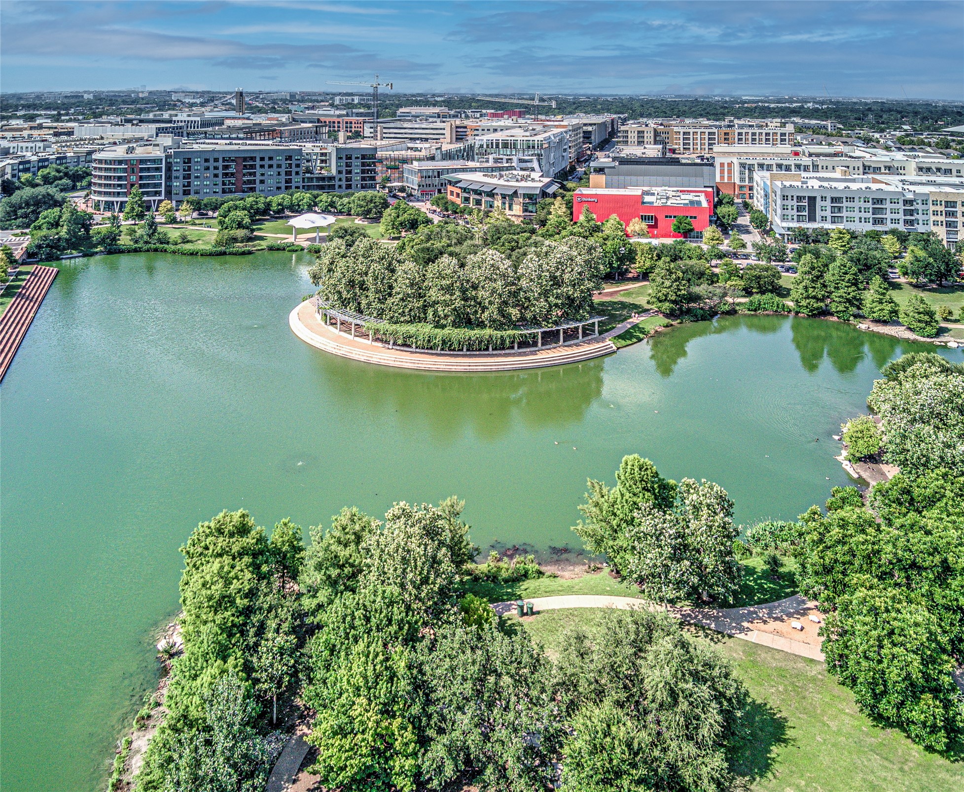 2805 McCurdy Street, Unit 14 Austin, TX 78723 - Photo 37 of 40 An aerial panorama reveals a serene community lake surrounded by verdant parks and urban structures.