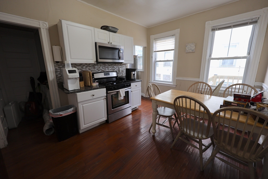 33-35 Ridgemont Street, Unit 1 Boston, MA 02134 - Photo 2 of 10 a living room with furniture a fireplace and a flat screen tv