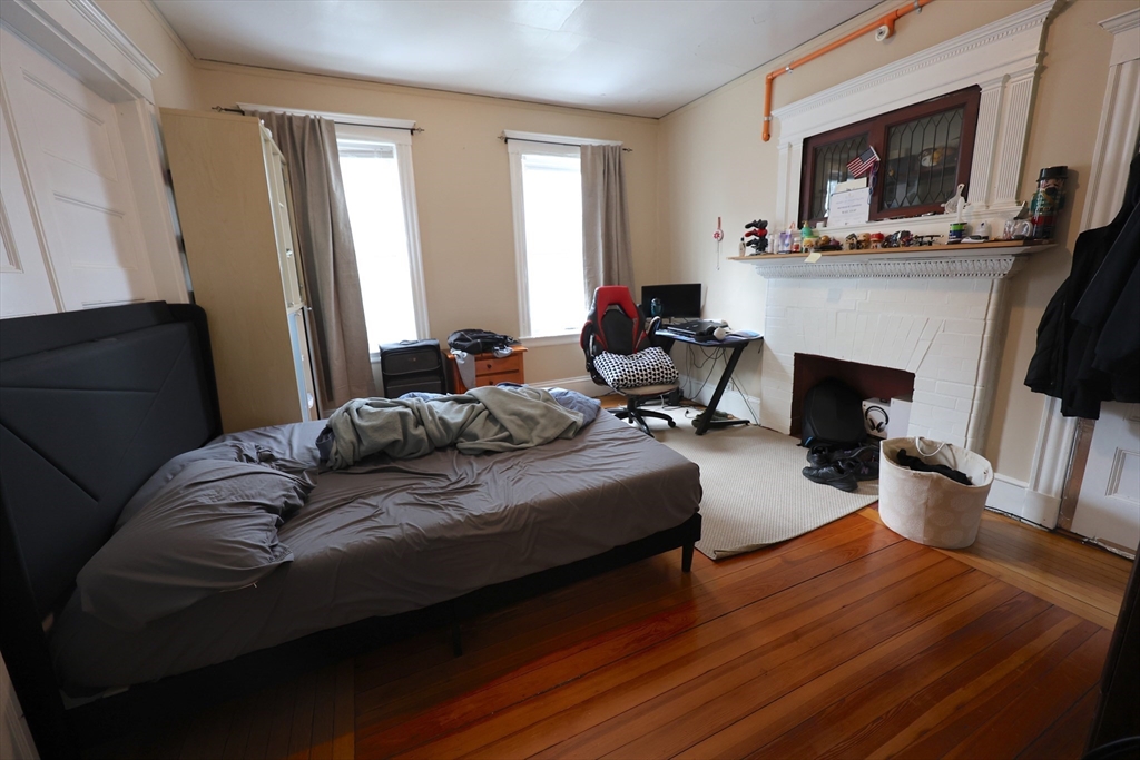 33-35 Ridgemont Street, Unit 1 Boston, MA 02134 - Photo 3 of 10 a bedroom with furniture and a fireplace