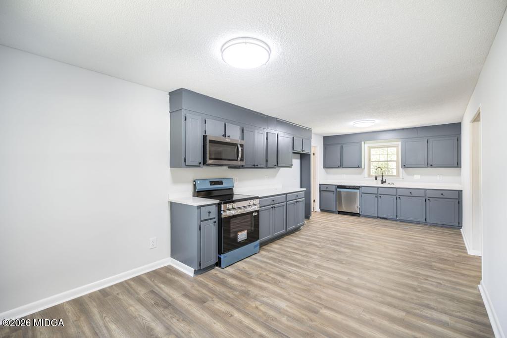 303 Woodhaven Road Centerville, GA 31028 - Photo 13 of 35 a large kitchen with stainless steel appliances a sink and cabinets