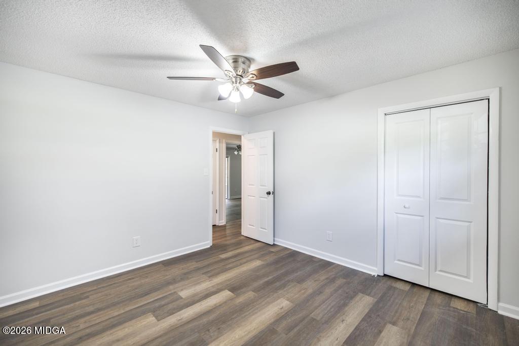 303 Woodhaven Road Centerville, GA 31028 - Photo 19 of 35 an empty room with wooden floor fan and windows