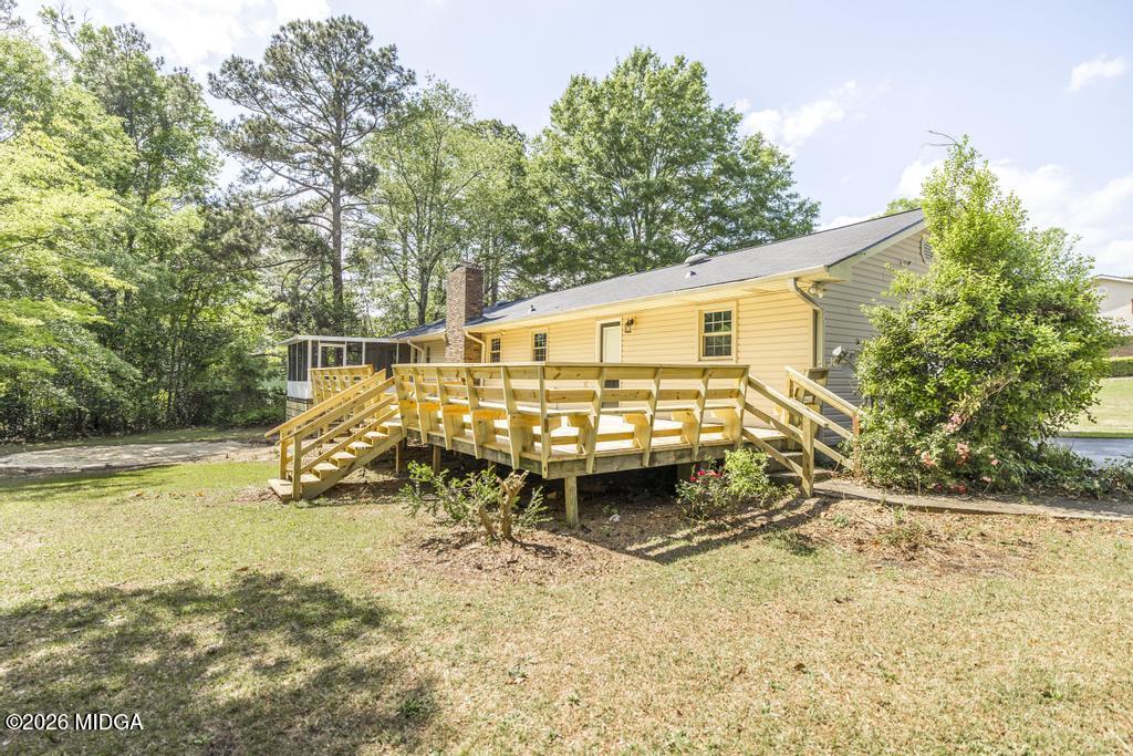 303 Woodhaven Road Centerville, GA 31028 - Photo 31 of 35 a view of a wooden house with pool and trees in the background