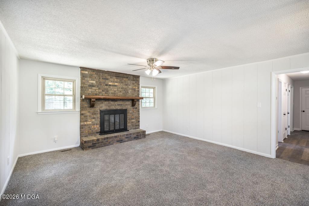 303 Woodhaven Road Centerville, GA 31028 - Photo 10 of 35 a view of an empty room with a fireplace and a window